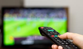 Billede af fjernbetjening og fodbold i TV